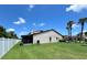 Spacious backyard with lush green lawn, screened patio, and air conditioning unit at 7360 Ulmerton Rd # 16A, Largo, FL 33771