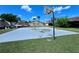 Community basketball court provides a recreational space, surrounded by green grass and mature trees at 7360 Ulmerton Rd # 16A, Largo, FL 33771