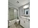 Bathroom featuring a shower-tub combination with glass doors and vanity with drawers at 7360 Ulmerton Rd # 16A, Largo, FL 33771