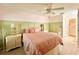 Cozy bedroom with pink bedding, ceiling fan, and ensuite bathroom entrance at 7360 Ulmerton Rd # 16A, Largo, FL 33771