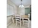 Cozy dining area with chandelier, white chairs and a wooden dining table at 7360 Ulmerton Rd # 16A, Largo, FL 33771