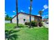 Well-maintained house exterior with palm trees, green lawn, and mature landscaping at 7360 Ulmerton Rd # 16A, Largo, FL 33771