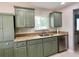 Kitchen sink with green cabinets, granite countertops, stainless steel appliances, and a tiled backsplash at 7360 Ulmerton Rd # 16A, Largo, FL 33771