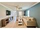 Spacious living room with light blue accent wall, sectional sofa and large tv at 7360 Ulmerton Rd # 16A, Largo, FL 33771