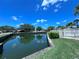 Calm pond reflects the blue sky and surrounding greenery, set behind a white fence and lush lawn at 7360 Ulmerton Rd # 16A, Largo, FL 33771
