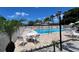 Community pool features a brick deck, white fence, palm trees, and seating area for residents to enjoy at 7360 Ulmerton Rd # 16A, Largo, FL 33771
