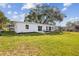 A well-maintained backyard featuring lush green grass and a clean exterior, complete with a patio and seating for relaxation at 75 New Jersey Dr, Dunedin, FL 34698