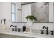 Close up of the bathroom double sink vanity with black fixtures and white marble countertop at 75 New Jersey Dr, Dunedin, FL 34698