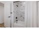 Bathroom featuring a white bathtub with marble tile backsplash and black shower fixtures at 75 New Jersey Dr, Dunedin, FL 34698