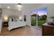 Bright bedroom featuring hardwood floors, slider to backyard, and a cushioned headboard at 75 New Jersey Dr, Dunedin, FL 34698
