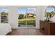 Bright bedroom with hardwood floors with a slider to the backyard with a fenced in view at 75 New Jersey Dr, Dunedin, FL 34698