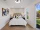 Bright bedroom featuring hardwood floors and a cushioned headboard with classic lamp lighting at 75 New Jersey Dr, Dunedin, FL 34698