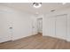 Bedroom with wood-look flooring, closet, and white walls at 75 New Jersey Dr, Dunedin, FL 34698
