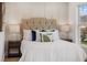 Up close shot of the bright bedroom featuring a cushioned headboard and classic lamp lighting at 75 New Jersey Dr, Dunedin, FL 34698