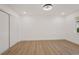 Bedroom with wood-look flooring, closet, window, and white walls at 75 New Jersey Dr, Dunedin, FL 34698