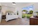 Bright bedroom featuring hardwood floors, slider to backyard, and a cushioned headboard at 75 New Jersey Dr, Dunedin, FL 34698