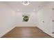 Bedroom with wood-look flooring, window, closet, and white walls at 75 New Jersey Dr, Dunedin, FL 34698