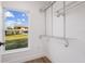 Walk-in closet featuring hardwood floors and a window overlooking the backyard at 75 New Jersey Dr, Dunedin, FL 34698