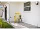 Inviting front porch with a yellow rocking chair and side table creates a cozy and welcoming entrance at 75 New Jersey Dr, Dunedin, FL 34698