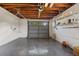 Epoxy floored garage featuring an automatic door and shelving with a leaf blower for home maintenance at 75 New Jersey Dr, Dunedin, FL 34698