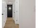 Bright hallway featuring wood-look flooring, white doors, and decorative mirror at 75 New Jersey Dr, Dunedin, FL 34698