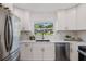 Modern kitchen features white cabinets, stainless steel appliances, and marble countertops at 75 New Jersey Dr, Dunedin, FL 34698