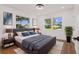 Main bedroom with a large bed, two windows, wood-look flooring, and decorative decor at 75 New Jersey Dr, Dunedin, FL 34698