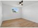 Bright bedroom features a ceiling fan and a window providing natural light, complemented by sleek, modern flooring at 8418 Westridge Dr, Tampa, FL 33615