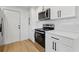 Newly updated kitchen featuring stainless steel appliances, white cabinetry and laminate flooring at 8418 Westridge Dr, Tampa, FL 33615