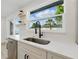 Updated kitchen showcasing new sink fixtures, floating shelves, and outside views from a large window at 8418 Westridge Dr, Tampa, FL 33615