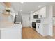 Well-lit kitchen featuring white cabinets, new stainless steel appliances, and modern laminate floors at 8418 Westridge Dr, Tampa, FL 33615