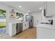 Modern kitchen featuring stainless steel appliances, white cabinetry and laminate flooring at 8418 Westridge Dr, Tampa, FL 33615