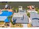 Aerial view of the property with a gray roof, a screened-in pool and boat dock on the canal at 8711 Thornwood Ln, Tampa, FL 33615