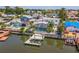 Waterfront backyard featuring a screened-in pool, dock with boat lift, and lush landscaping at 8711 Thornwood Ln, Tampa, FL 33615