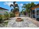 Backyard featuring a fire pit surrounded by stones and lush landscaping at 8711 Thornwood Ln, Tampa, FL 33615