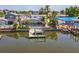 Waterfront backyard with a screened-in pool, boat dock, and lush palm trees at 8711 Thornwood Ln, Tampa, FL 33615