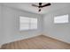 Bedroom featuring hardwood flooring, white walls and trim, and window with mini blinds at 8711 Thornwood Ln, Tampa, FL 33615