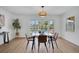 Bright dining room featuring wood floors, modern table and chairs, and outdoor pool view at 8711 Thornwood Ln, Tampa, FL 33615