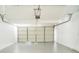 Spacious two-car garage with a white door and gray epoxy flooring at 8711 Thornwood Ln, Tampa, FL 33615