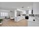 Open-concept kitchen featuring modern white cabinets, stainless steel appliances, and stone countertops at 8711 Thornwood Ln, Tampa, FL 33615
