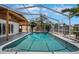 Sparkling enclosed pool featuring a screened enclosure and outdoor kitchen at 8711 Thornwood Ln, Tampa, FL 33615