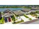 Aerial view features multiple homes, landscaping, and a peaceful lake creating a serene backdrop at 872 Olive Conch St, Ruskin, FL 33570