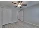 Bedroom featuring wood-look floors, ceiling fan, and large closet with a view to another room at 872 Olive Conch St, Ruskin, FL 33570