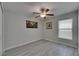 Bedroom with wood-look floors, ceiling fan, a large window, and decorative wall art at 872 Olive Conch St, Ruskin, FL 33570