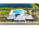 Aerial view of community clubhouse featuring a sparkling pool, playground, and lush landscaping near the serene lake at 872 Olive Conch St, Ruskin, FL 33570