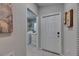 Bright hallway with access to laundry room, featuring modern appliances and white tile flooring at 872 Olive Conch St, Ruskin, FL 33570