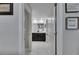 Hallway view leading to bathroom with dark vanity and framed decor on the walls at 872 Olive Conch St, Ruskin, FL 33570