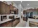 Modern kitchen with dark wood cabinetry, stainless steel appliances, and marble countertops at 872 Olive Conch St, Ruskin, FL 33570