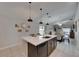 Modern kitchen island with seating, pendant lighting, and an open view of the dining area at 872 Olive Conch St, Ruskin, FL 33570
