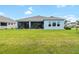 Spacious backyard with lush green grass and a screened lanai, offering a private outdoor retreat at 8916 Windlass Cv, Parrish, FL 34219